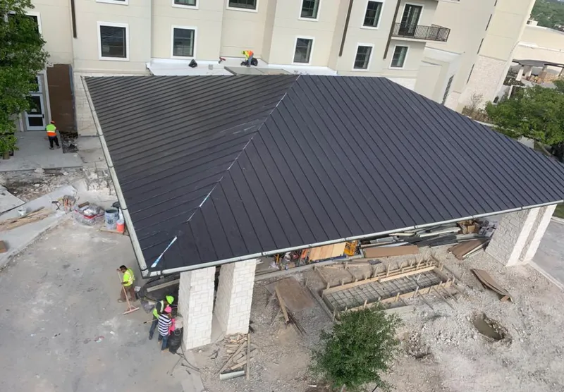 Metal roofing installation team working on a commercial building in South Miami